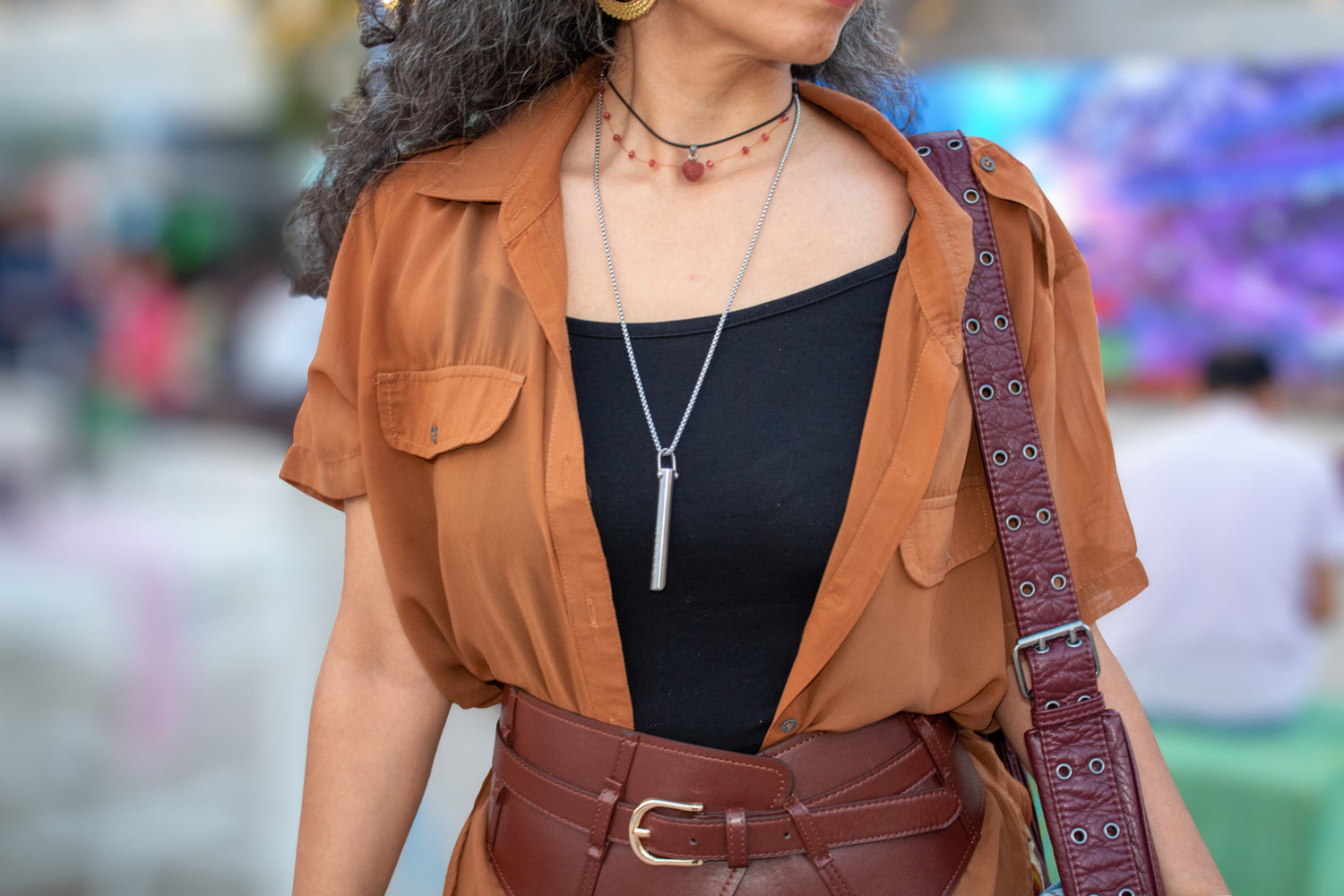 316L stainless steel Exhale Pendant worn as a necklace on a woman outdoors, styled with layered jewelry.